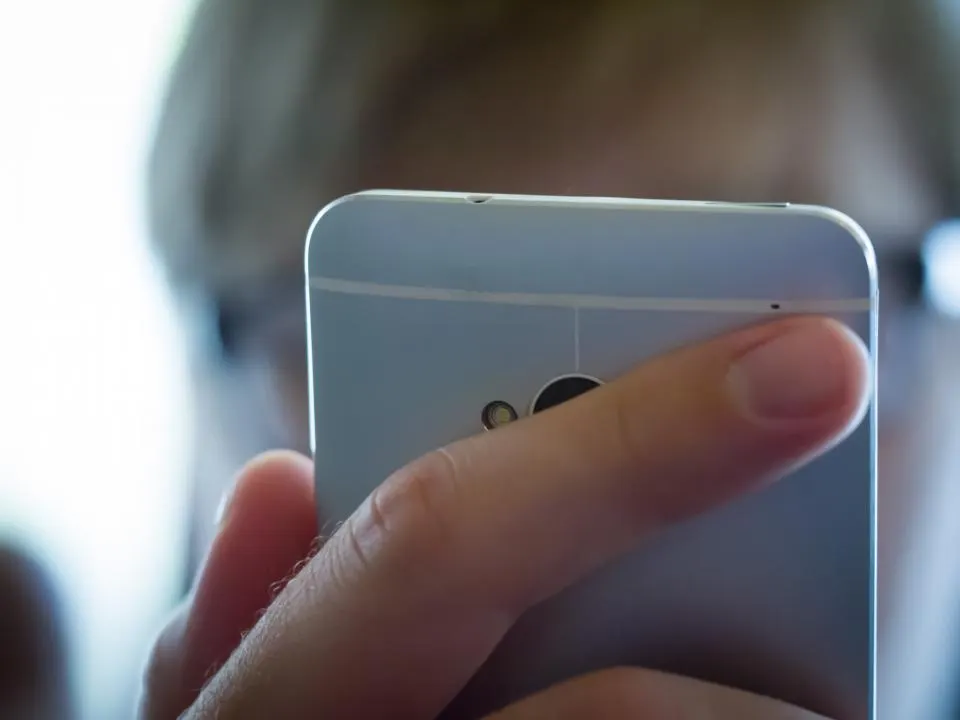 Hand holding a phone with a budget screen